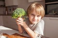 Child holding green broccoli.  Healthy  food concept. Child nutrition. Fresh vegetables in the hands of a cheerful boy child Royalty Free Stock Photo