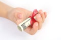 Child holding in a hand gift of money american hundred dollar bills with red ribbon on white background