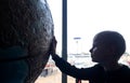 Child holding hand on globe. A child hand on a large model of the planet earth. The concept of protecting the environment, caring Royalty Free Stock Photo