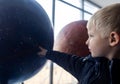 Child holding hand on globe. A child hand on a large model of the planet earth. The concept of protecting the environment, caring Royalty Free Stock Photo