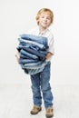 Child holding jeans stack. Kids clothing fashion