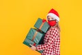 Child with boxes in green packaging with gifts in front of a blue background. Christmas mood