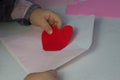 Child holding letter with red paper heart,love letter for Valentine's day,gift for Mothers day,little girl put Royalty Free Stock Photo