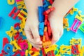 Child holding magnetic plastic letters in hands Royalty Free Stock Photo