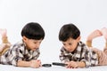 Child holding magnifying glass on white background. Boy with a magnifying glass in studio. Royalty Free Stock Photo