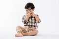 Child holding magnifying glass on white background. Boy with a magnifying glass in studio. Royalty Free Stock Photo