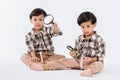 Child holding magnifying glass on white background. Boy with a magnifying glass in studio. Royalty Free Stock Photo