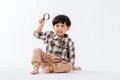 Child holding magnifying glass on white background. Boy with a magnifying glass in studio. Royalty Free Stock Photo