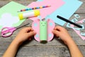 Child holding paper butterfly crafts in hands. Child shows a fun paper crafts. Stationery on an old wooden table