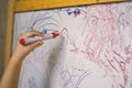 Child holding a pencil in whiteboard closeup