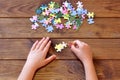 Child holding puzzles in hands. A set of jigsaw puzzles on wooden table