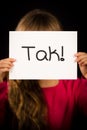 Child holding sign with Danish word Tak - Thank You