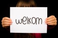 Child holding sign with Dutch word Welkom - Welcome