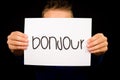 Child holding sign with French word Bonjour - Hello