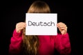 Child holding sign with German word Deutsch - German in English