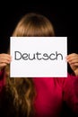 Child holding sign with German word Deutsch - German in English Royalty Free Stock Photo