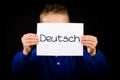 Child holding sign with German word Deutsch - German in English Royalty Free Stock Photo