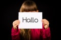 Child holding sign with German word Hallo - Hello in English Royalty Free Stock Photo