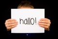 Child holding sign with German word Hallo - Hello in English