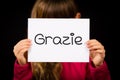 Child holding sign with Italian word Grazie - Thank You Royalty Free Stock Photo