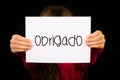 Child holding sign with Portuguese word Obrigado - Thank You Royalty Free Stock Photo