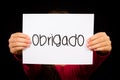 Child holding sign with Portuguese word Obrigado - Thank You Royalty Free Stock Photo