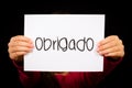 Child holding sign with Portuguese word Obrigado - Thank You Royalty Free Stock Photo