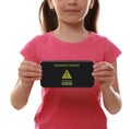 Child holding smartphone with installed parental control on white background, closeup. Cyber safety