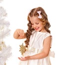 Child holding snowflake to decorate Christmas tree .