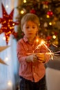 Child holding sparkler at home at New Years Eve, enjoying happy evening