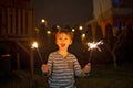 Child holding sparkler at home at New Years Eve, enjoying happy evening