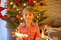 Child holding sparkler at home at New Years Eve, enjoying happy evening Royalty Free Stock Photo