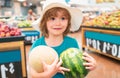 Child holding watermelon in supermarket. Sale, consumerism and kids concept. Vegetables in store. Royalty Free Stock Photo
