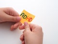 A child holding a yellow paper note in his hands with the abbreviation ADHD on it