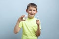 Child holds big tooth and toothbrush on a blue background. Caring for teeth. Dentistry and healthcare concept. Healthy teeth