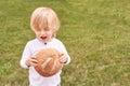 Child holds and bite round bread. Healthy food