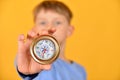 A child holds a compass in his hand and shows it to the camera, closeup. The concept of children`s travel and joining the ranks o