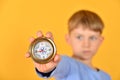A child holds a compass in his hand and shows it to the camera, closeup. The concept of children`s travel