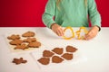 The child holds cookie forms in the shape of a man and a Christmas tree for making gingerbread cookies. Royalty Free Stock Photo