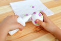 Child holds a decoupage Easter egg and glue in hands. Child glues the flower fragments of napkin to the egg. Easter decoupage Royalty Free Stock Photo