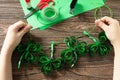 Child holds Garland St. Patrick`s Day clover, craft from paper. Handmade. Children`s art project