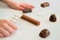 Child holds in hand a package of pills. Tablets are among the candies. Royalty Free Stock Photo