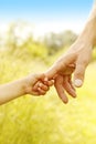 Child holds the hand of parent