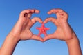 Child holds hands up to sky in the shape of a heart with starfish. Love shape child hands with starfish.