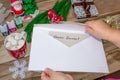 A child holds a letter to Santa Claus at the North Pole to Lapland, children`s hands on a wooden background with decorations Royalty Free Stock Photo