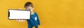 child holds the phone in his hand for advertising on a yellow background. Color