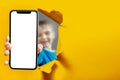 child holds the phone in his hand for advertising on a yellow background. Color