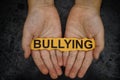 Child holds piece of paper with word Bullying in his hands