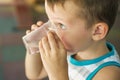 The child holds a plastic cup of water in his hands. Child drinks water. Cute little boy drinking fresh water from plastic cup Royalty Free Stock Photo