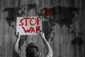 The child holds a poster stop war on background of a world map Royalty Free Stock Photo